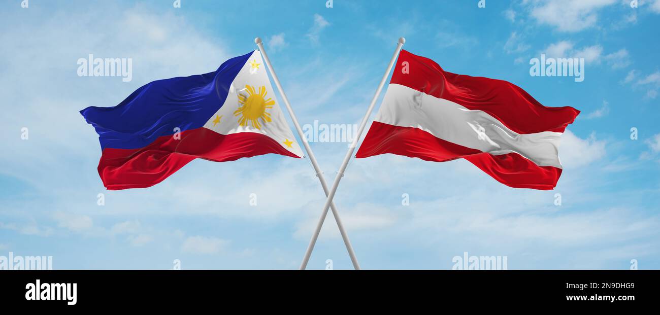 two crossed flags Austria and Philippines waving in wind at cloudy sky ...