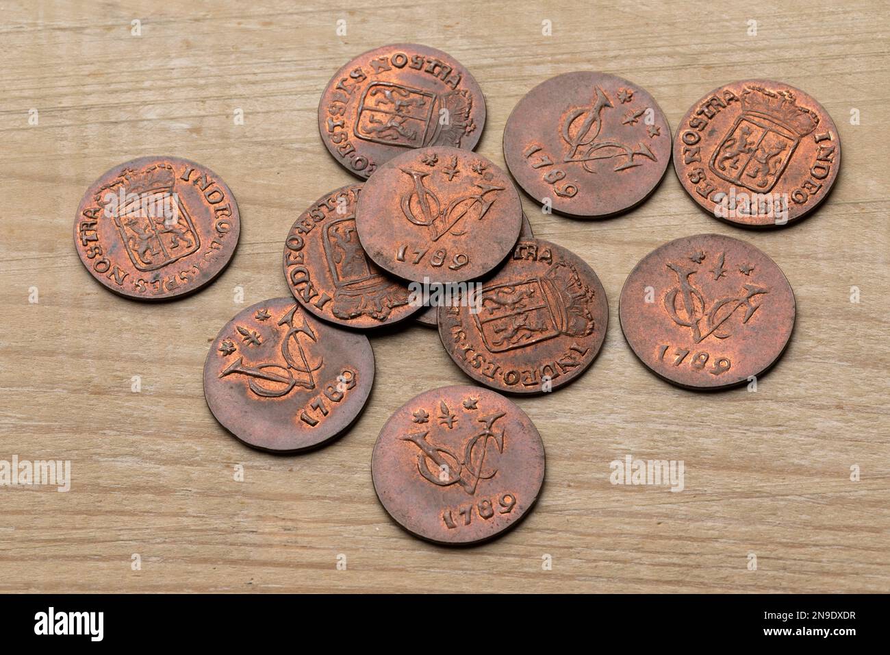 Heap of old antique Dutch VOC coins from 1789 on a wooden background close up Stock Photo