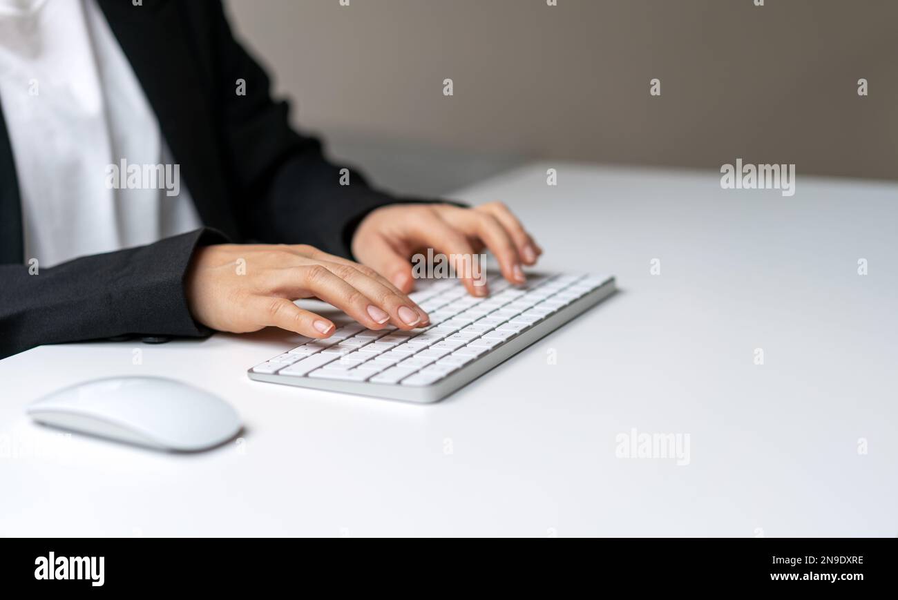 Female hands on white computer's keyboard close-up photography with copy space. Template typing on keyboard. Stock Photo