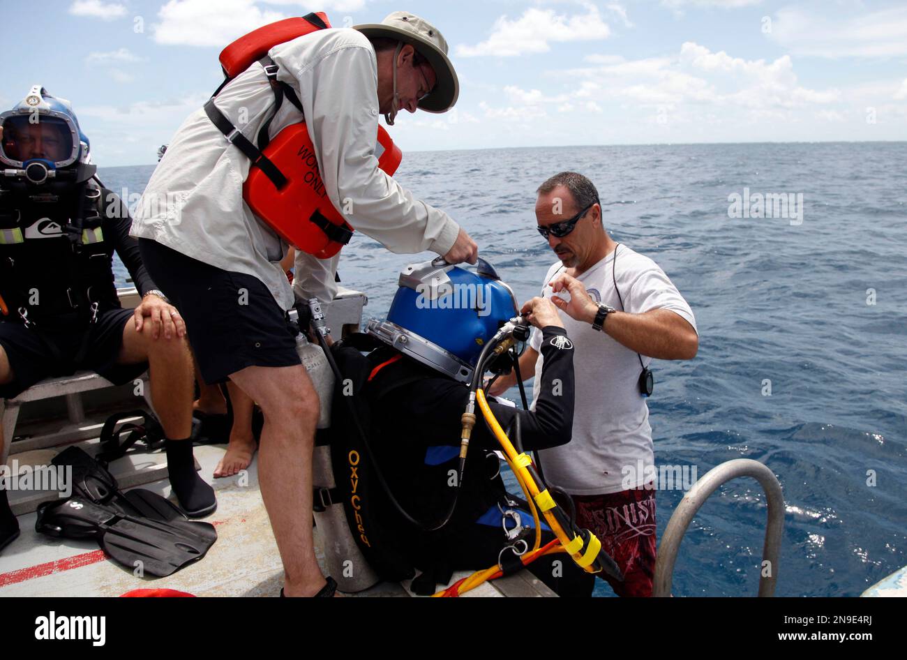 Sylvia Earle, center, puts on her helmet as Dale Stokes, left, and
