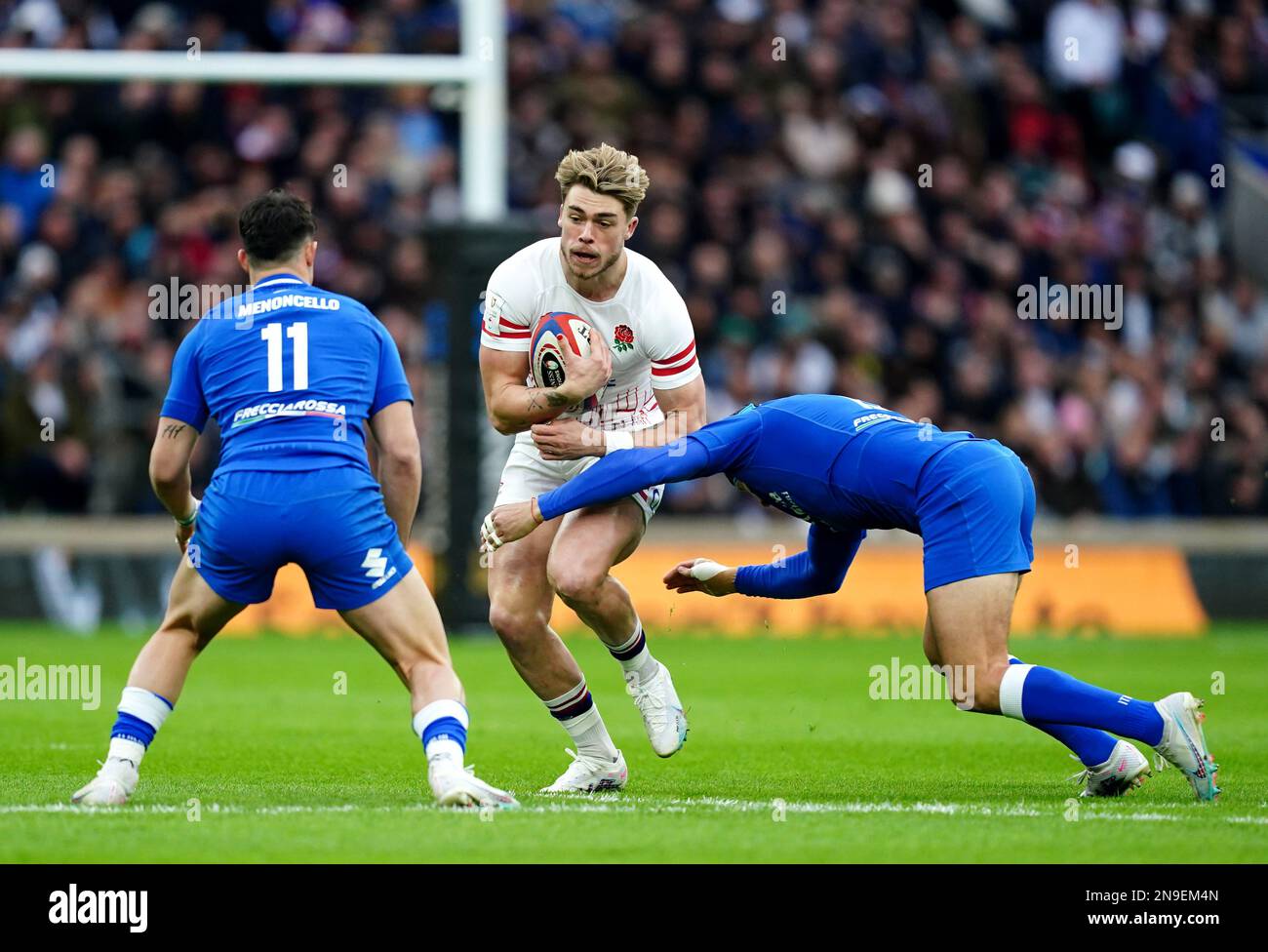 England's Oliver Hassell-Collins (centre) tackled by Italy's Italy's Tommaso Menoncello (left) and Ignacio Brex Juan during the Guinness Six Nations match at Twickenham Stadium, London. Picture date: Sunday February 12, 2023. Stock Photo