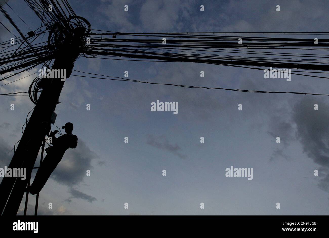 A Cambodian worker repairs telephone line in Phnom Penh, Monday July 9