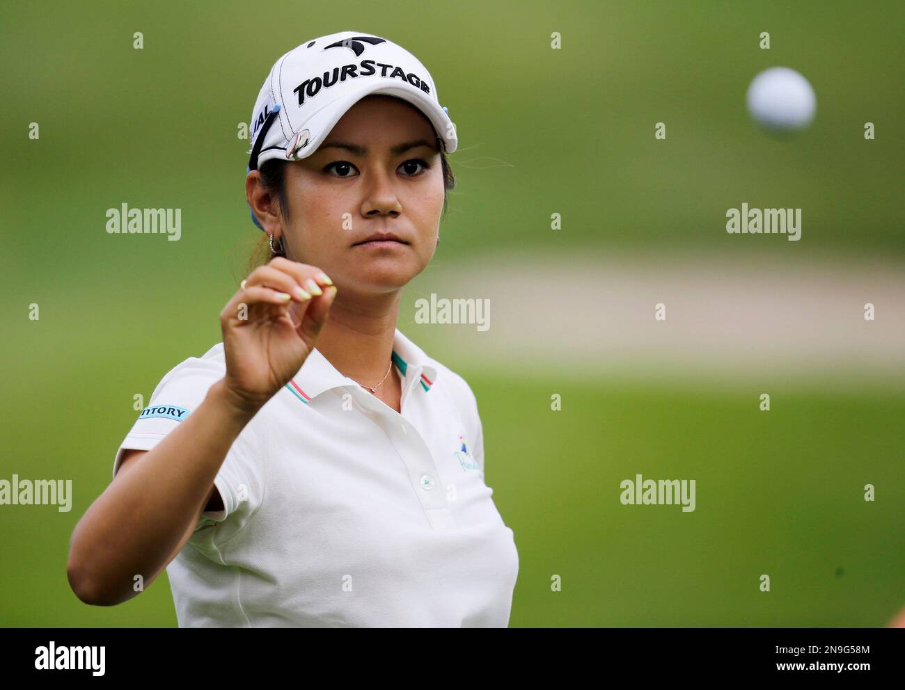 Japan's Ai Miyazato takes a ball from her caddie while hitting the