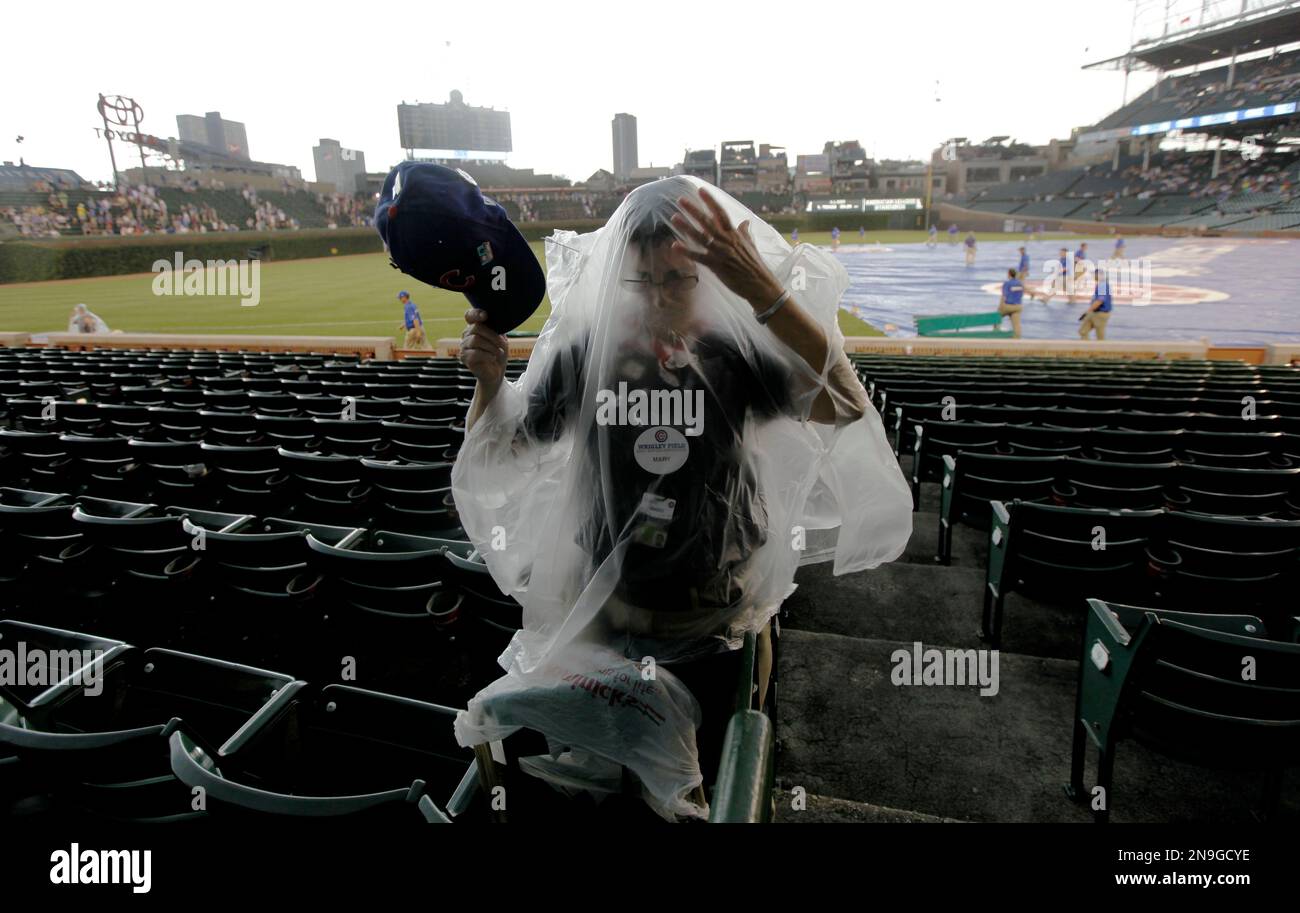 Chicago Cubs services ambassador Mary R. puts on her rain gear during a