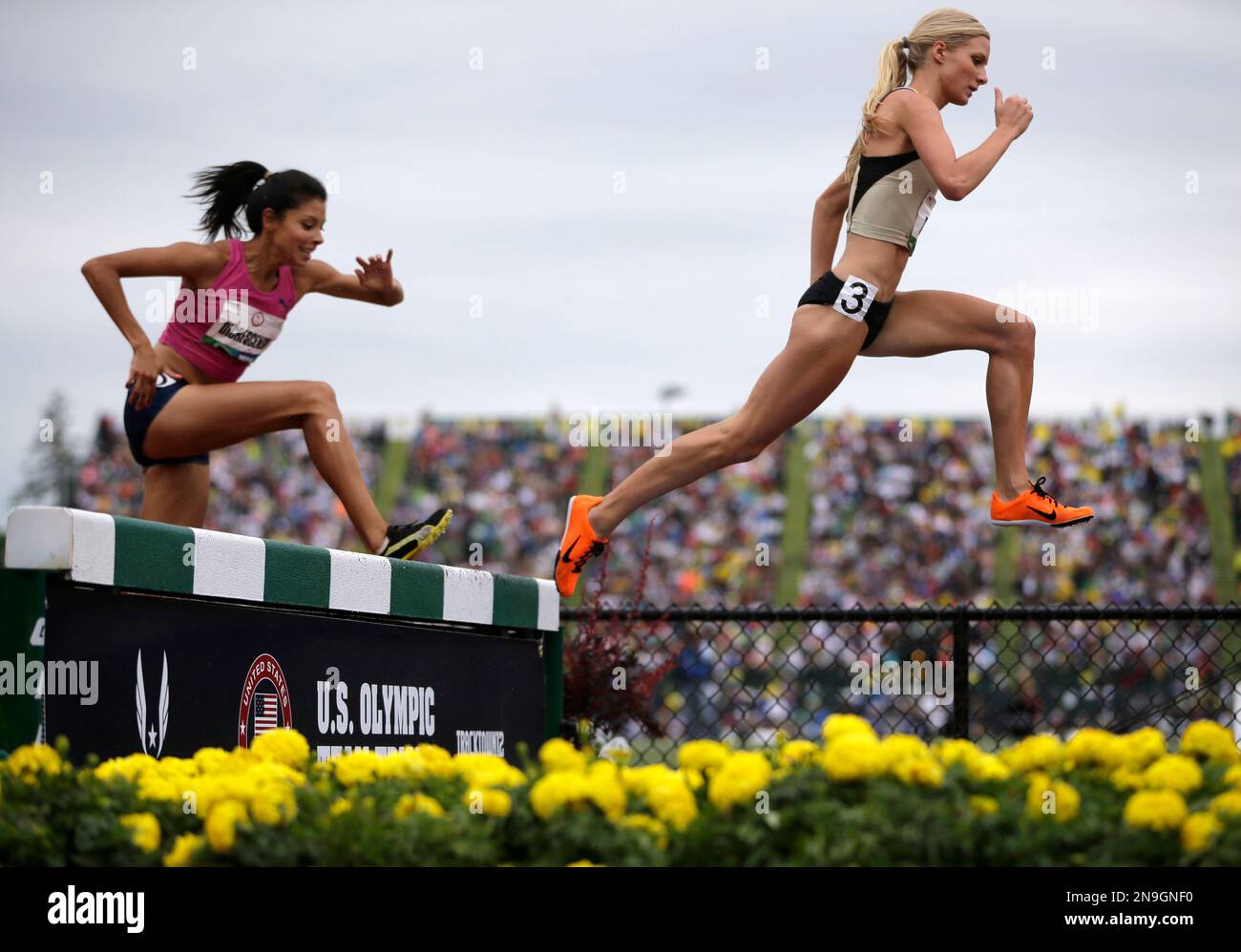 Emma Coburn, right, leads Delilah DiCrescenzo over the water jump in