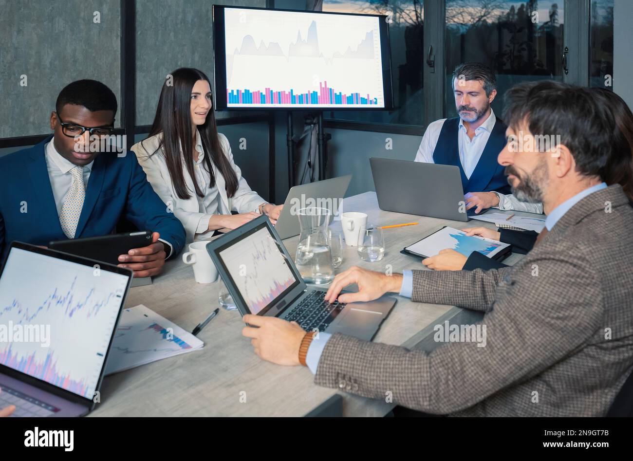 Young Smiling Business People on Meeting in Office. Group of Young Coworkers Sitting Together at Table in Modern Office. Business Team Working Togethe Stock Photo