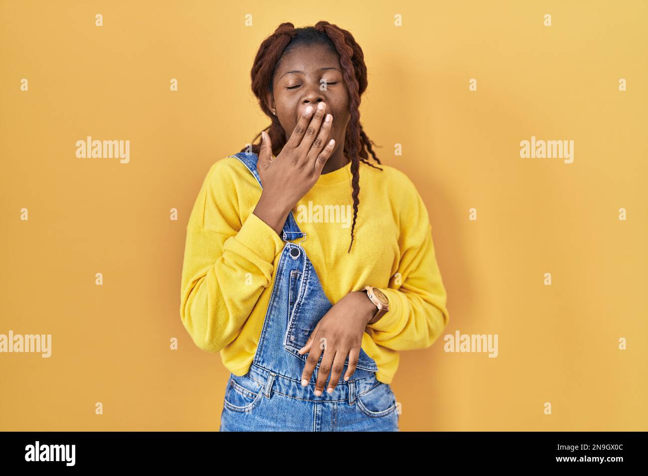 African Woman Standing Over Yellow Background Bored Yawning Tired Covering Mouth With Hand 4322