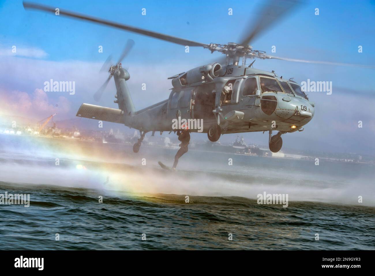 A US Naval Aircewman (Helicopter), jumps from MH-60S helicopter during exercise Stock Photo
