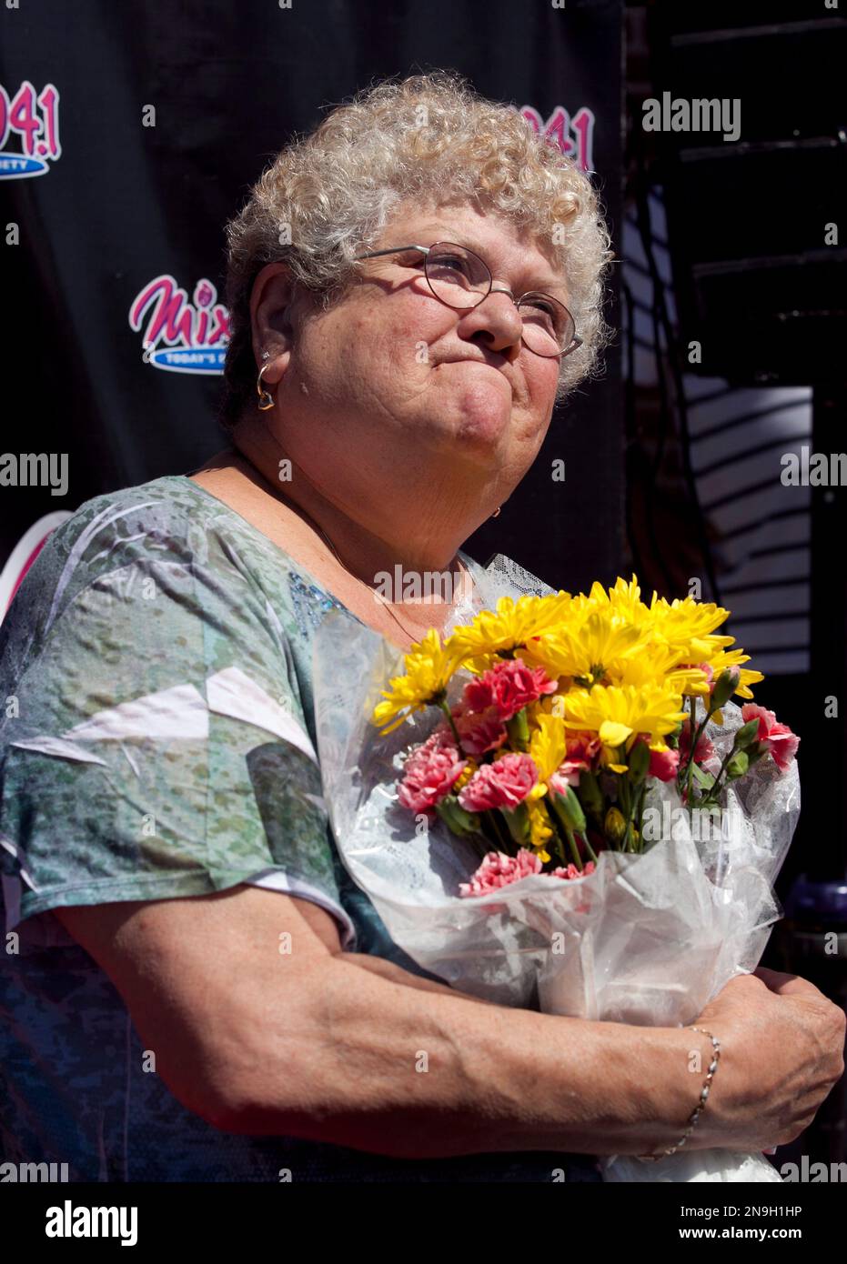 Bus monitor Karen Klein, of Greece, N.Y., holds flowers during an award ceremony in her honor at