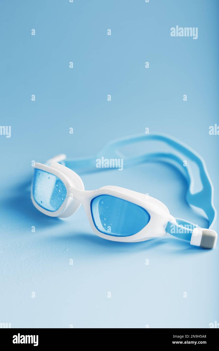 White swimming goggles on a blue background in a minimalist style with free space Stock Photo