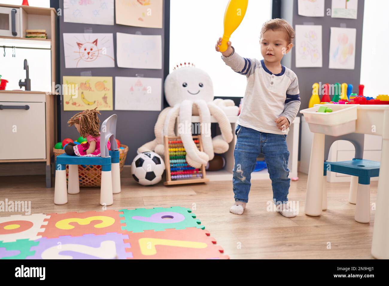 Adorable caucasian boy playing with pin bowling standing at