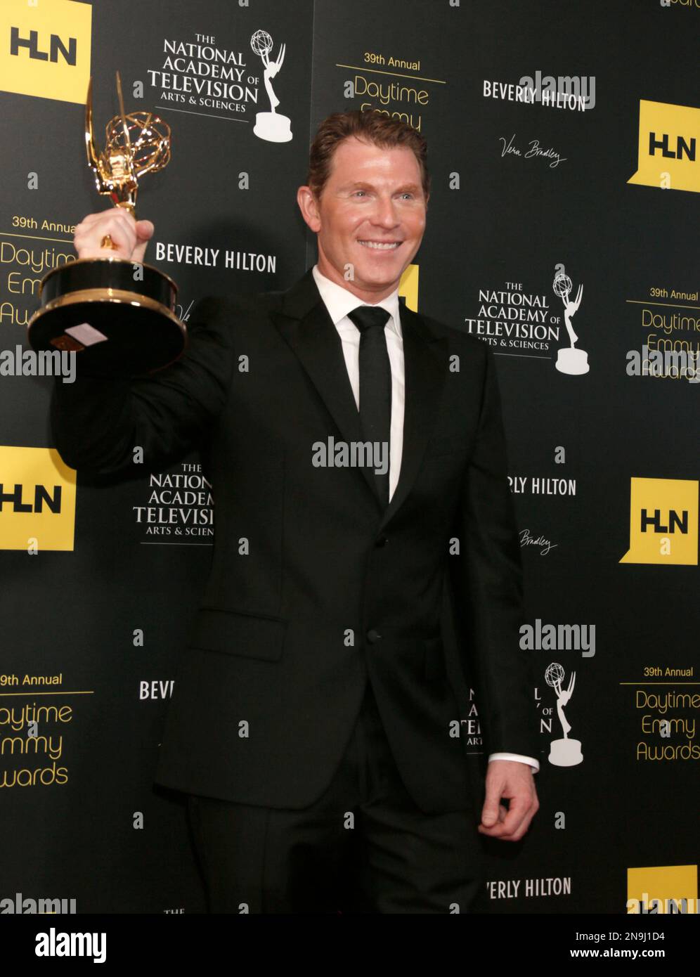 Bobby Flay poses backstage with the culinary program award for