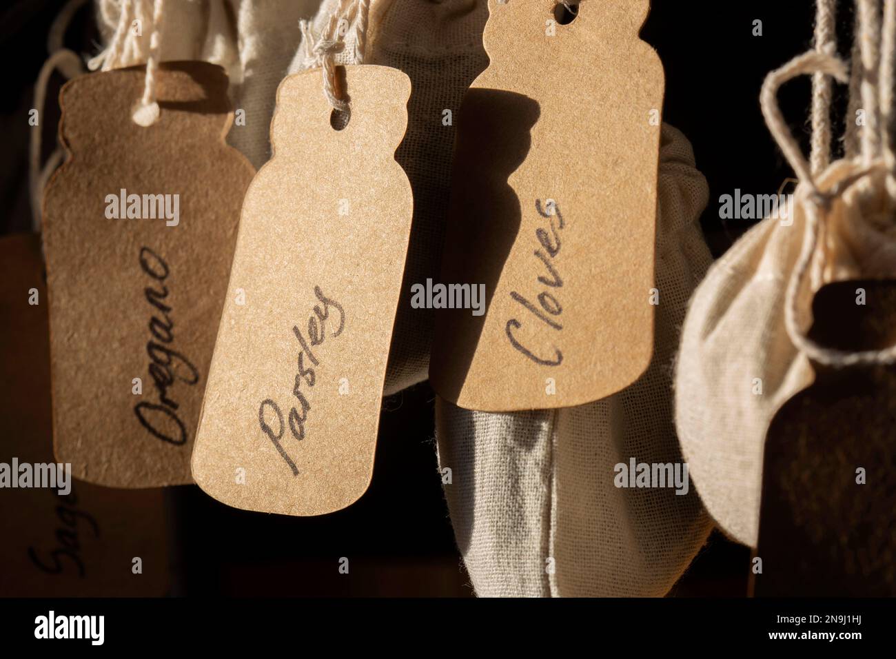 Herbs in jute bags sacks, parsley, sage, oregano and cloves, hanging on  metal hooks in a kitchen. labelled with card tags Stock Photo - Alamy