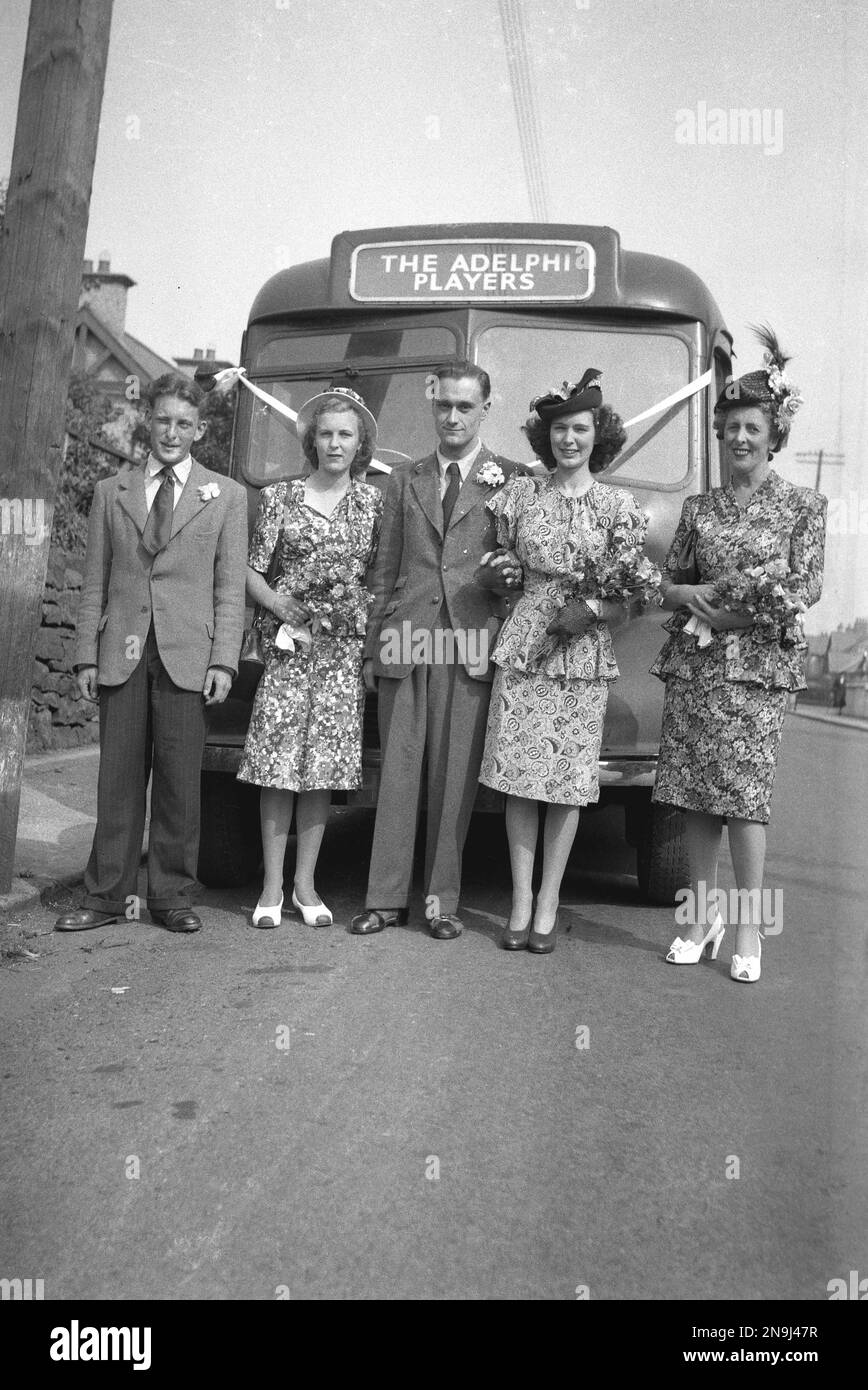1940s, historical, members of 'The Adelphi Players' theatrical society stand together for a photo at the front of their touring bus, a Bedford, England, UK. Stock Photo