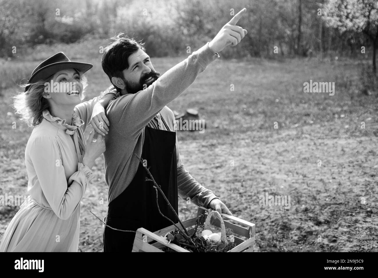 Young Couple gardening in the garden. Become organic farmer. Two people gardening in the backyard garden. Couple in the farm on countryside background Stock Photo