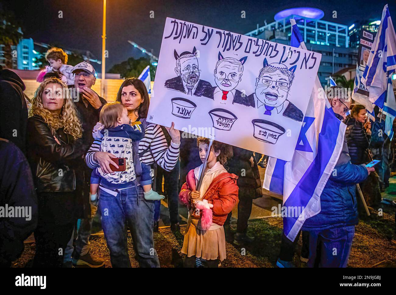 Tel Aviv, Israel. 11th Feb, 2023. Protestors hold a placard with Israeli minister, L to R, Betzalel Smotrich, minister of finance, Yariv Levin, minister of justice, and Itamar Ben-Gvir, minister of national security, as cats with the writing: we will not let the cats keep the cream during a protest against the government's judicial reform plan. Over 160000 rallied for Democracy for the sixth consecutive week across Israel against controversial legal reforms touted by Benjamin Netanyahu's rightwing government. Credit: SOPA Images Limited/Alamy Live News Stock Photo