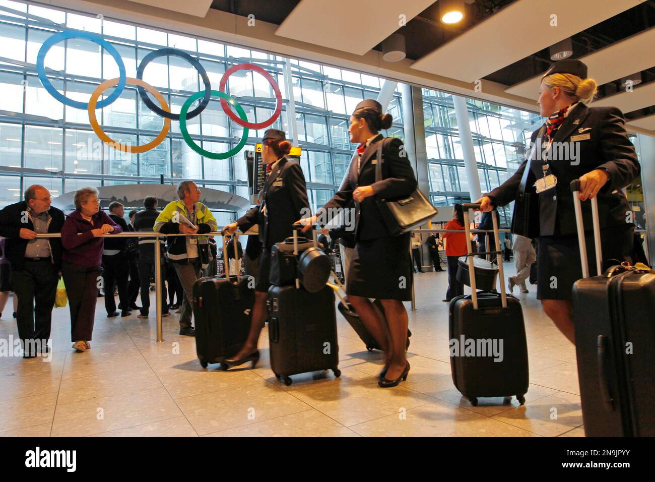 Airline crew exiting the arrival terminal, look at giant Olympic Rings ...