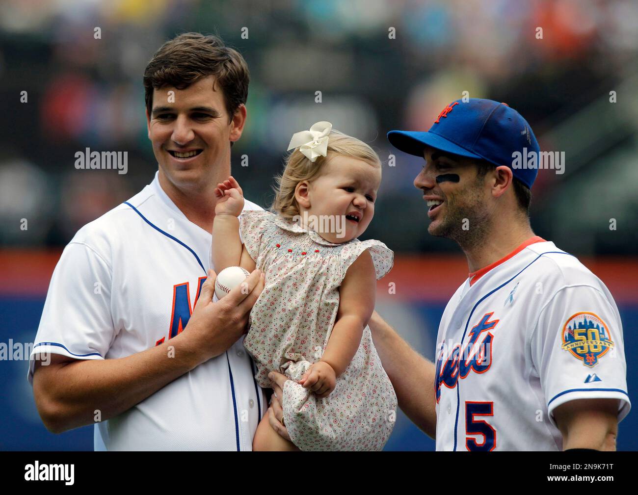 New York Giants quarterback Eli Manning, left, holds daughter Ava as he(00)
