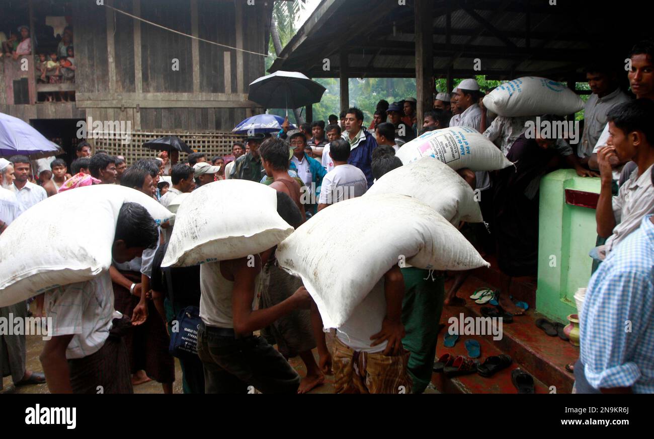 Muslims unload rice sacks to their refugee camp at a village in Sittwe ...