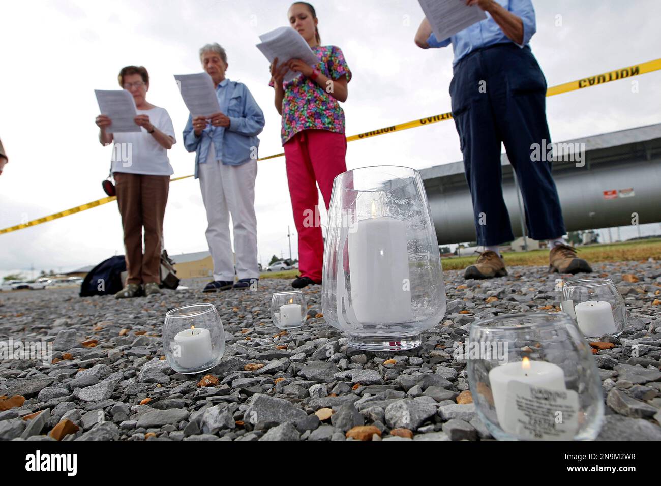 Death penalty opponents sing behind five lit candles during a memorial