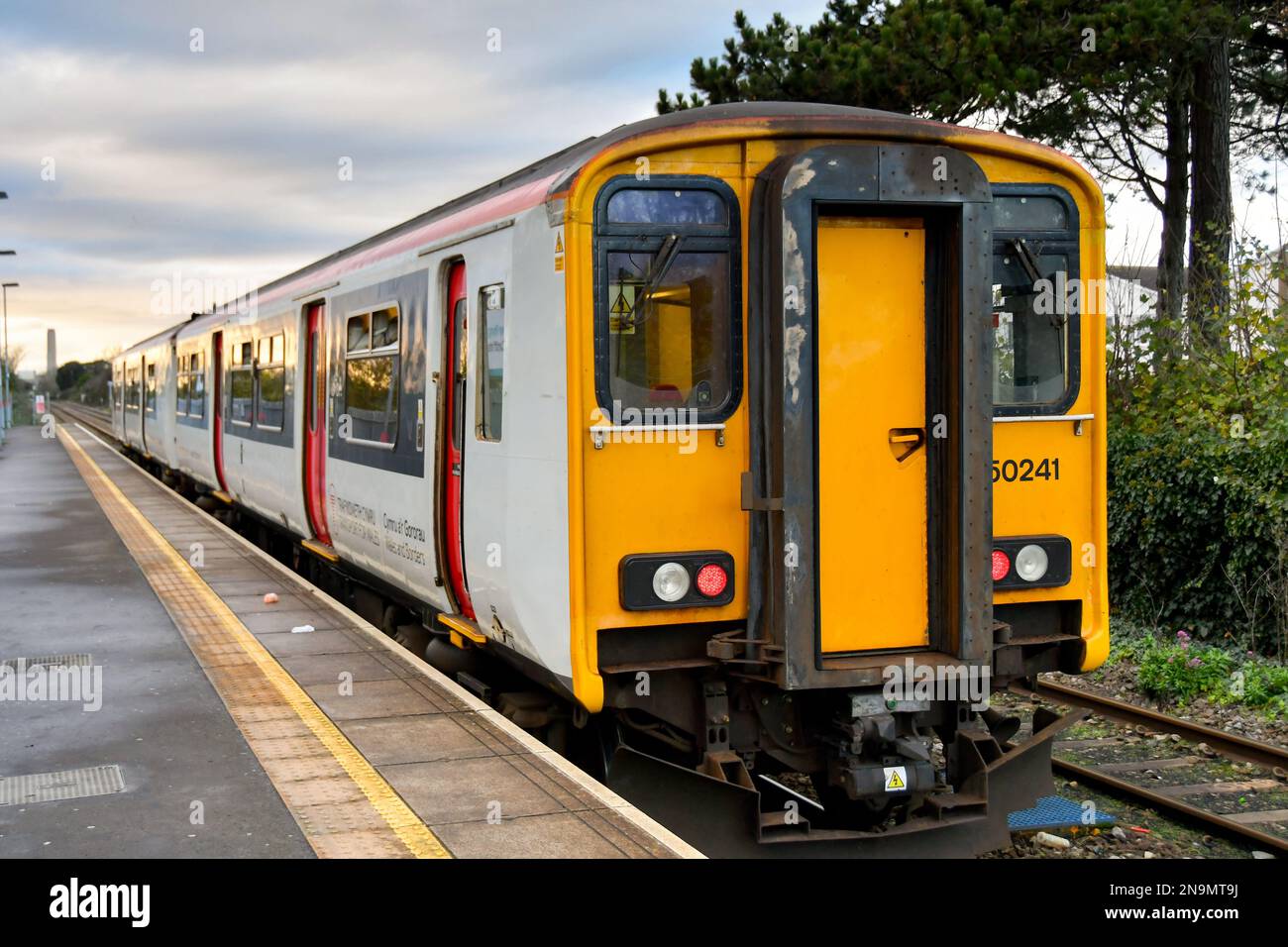 Rhoose, Wales - November 2022: Train about to leave Rhoose railway station at sunset. The train is operated by Transport for Wales. Stock Photo