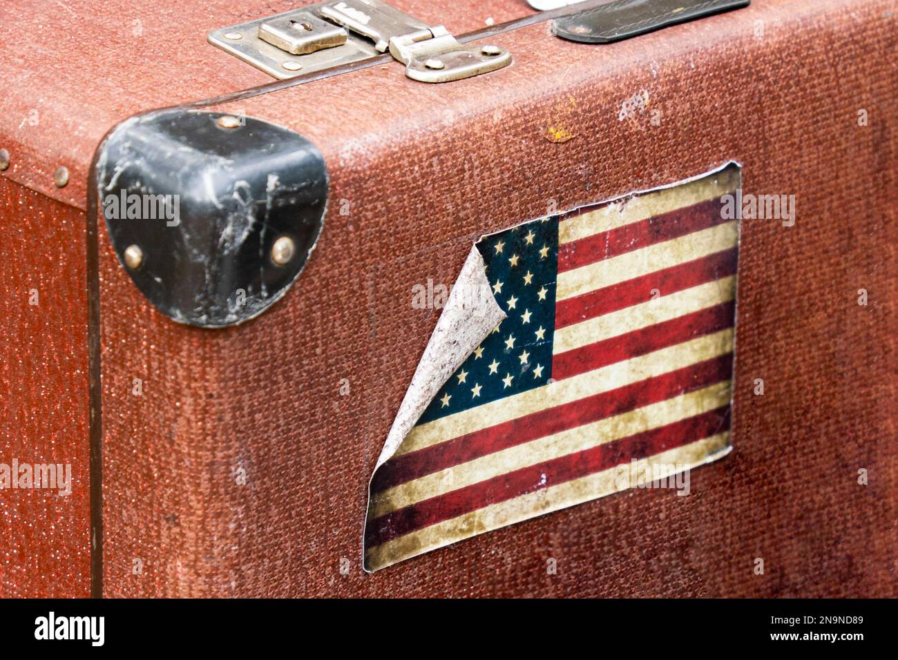 Old brown suitcase with worn American flag Stock Photo Alamy