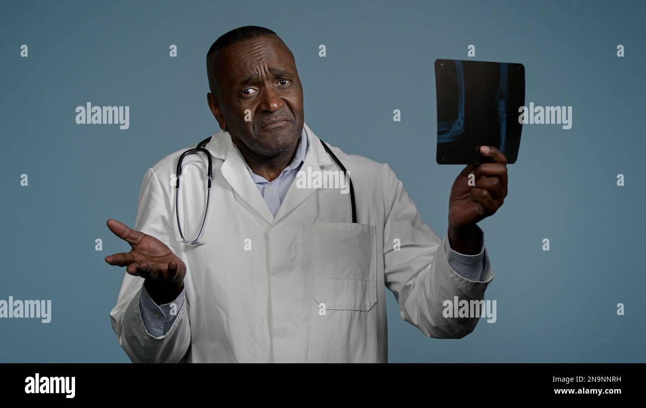 Mature serious man radiologist doctor examining x-ray check results ...