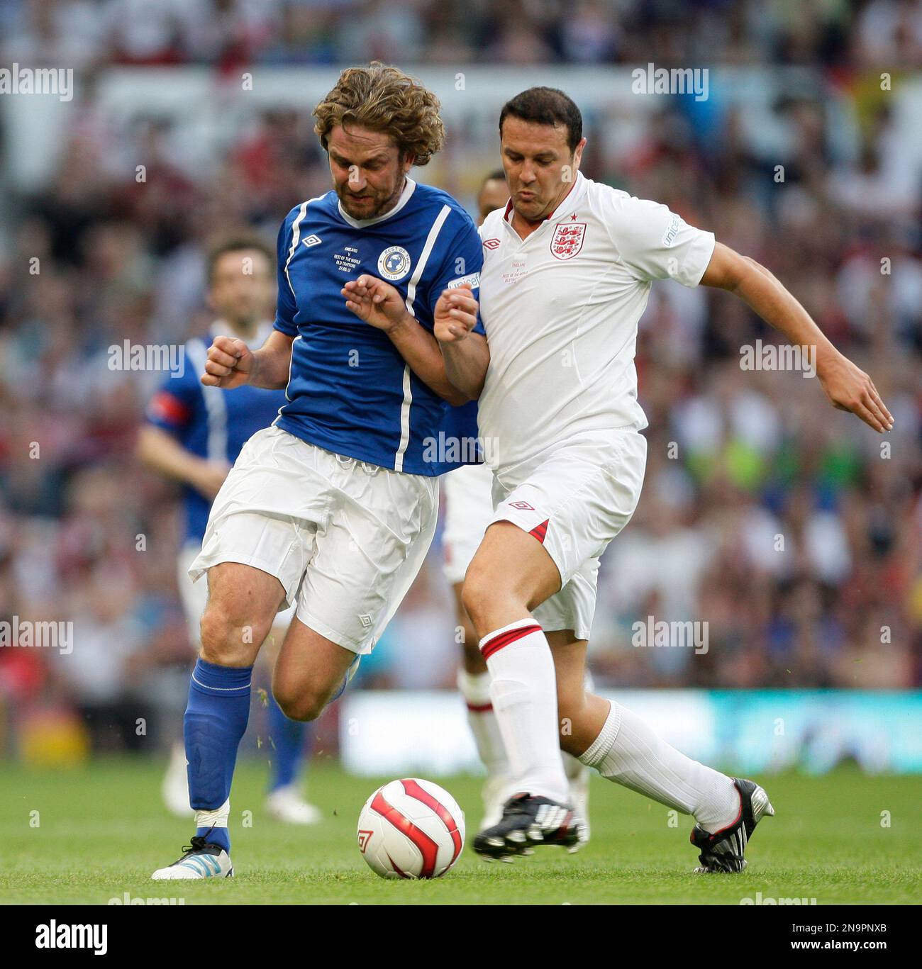 Gerard Butler of the Rest Of The World team, left, is tackled by England's  Maddy McGuiness during the Soccer Aid charity soccer match in aid of UNICEF  at Old Trafford Stadium, Manchester,, image size:1300x1367