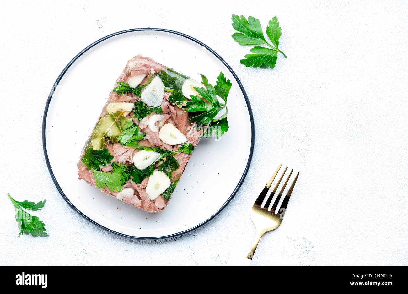 Aspic meat, cold boiled beef in spiced jelly broth on plate.. White