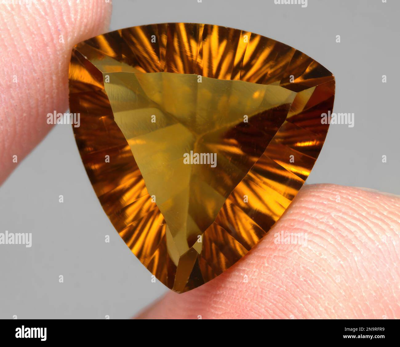 Natural gem yellow citrine on gray background Stock Photo