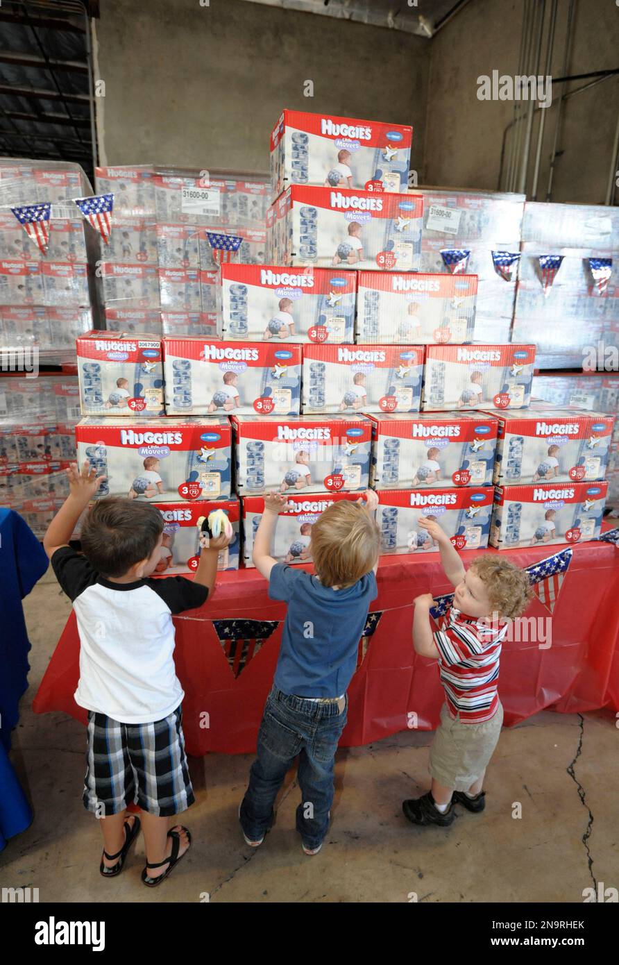 Children of military families play amongst boxes of Huggies Camo