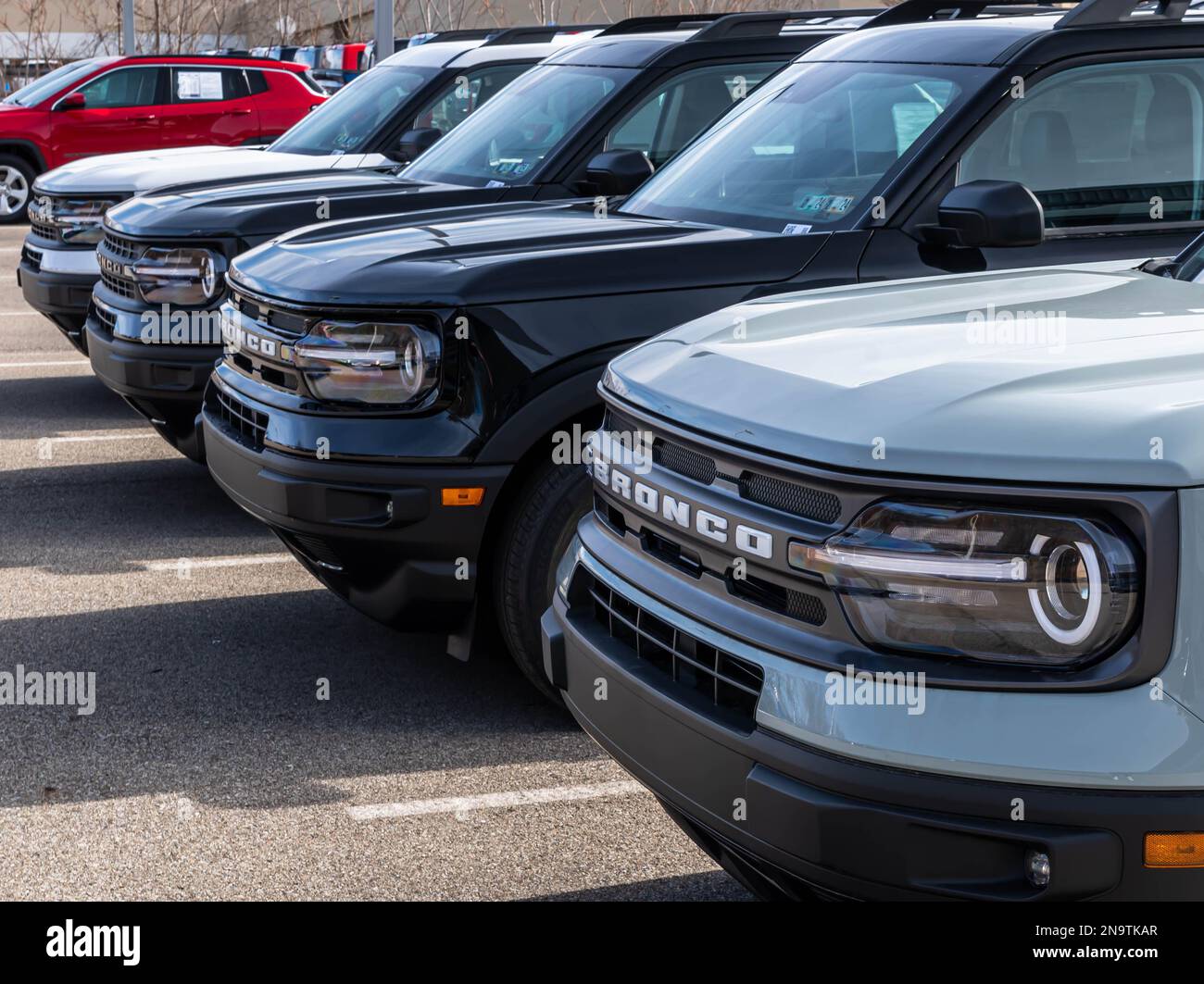 A different colored Ford Bronco SUVs lined up for sale at a dealership