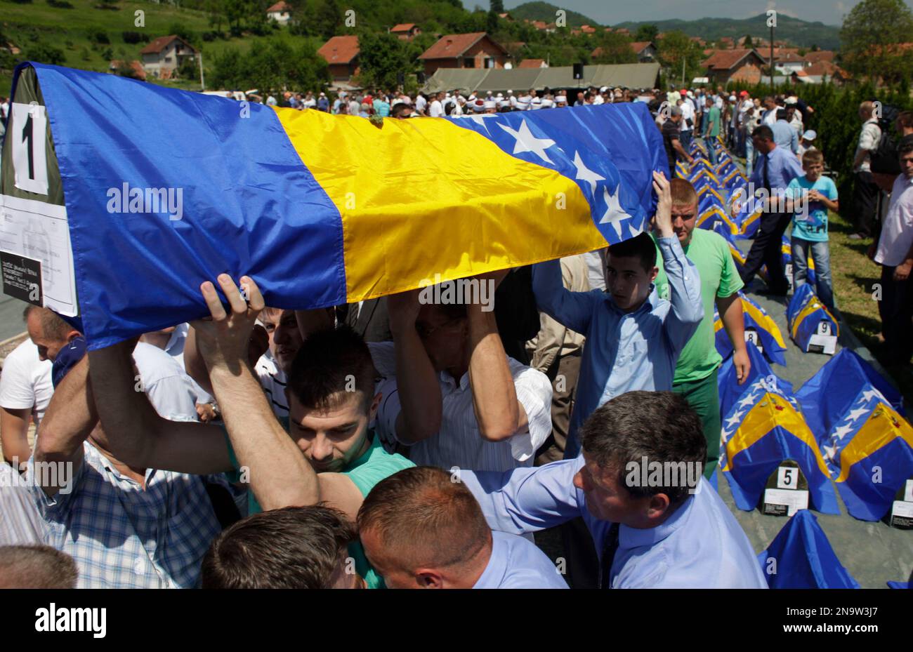 Bosnian Muslim men carry a coffin during a funeral for 34 Bosnian