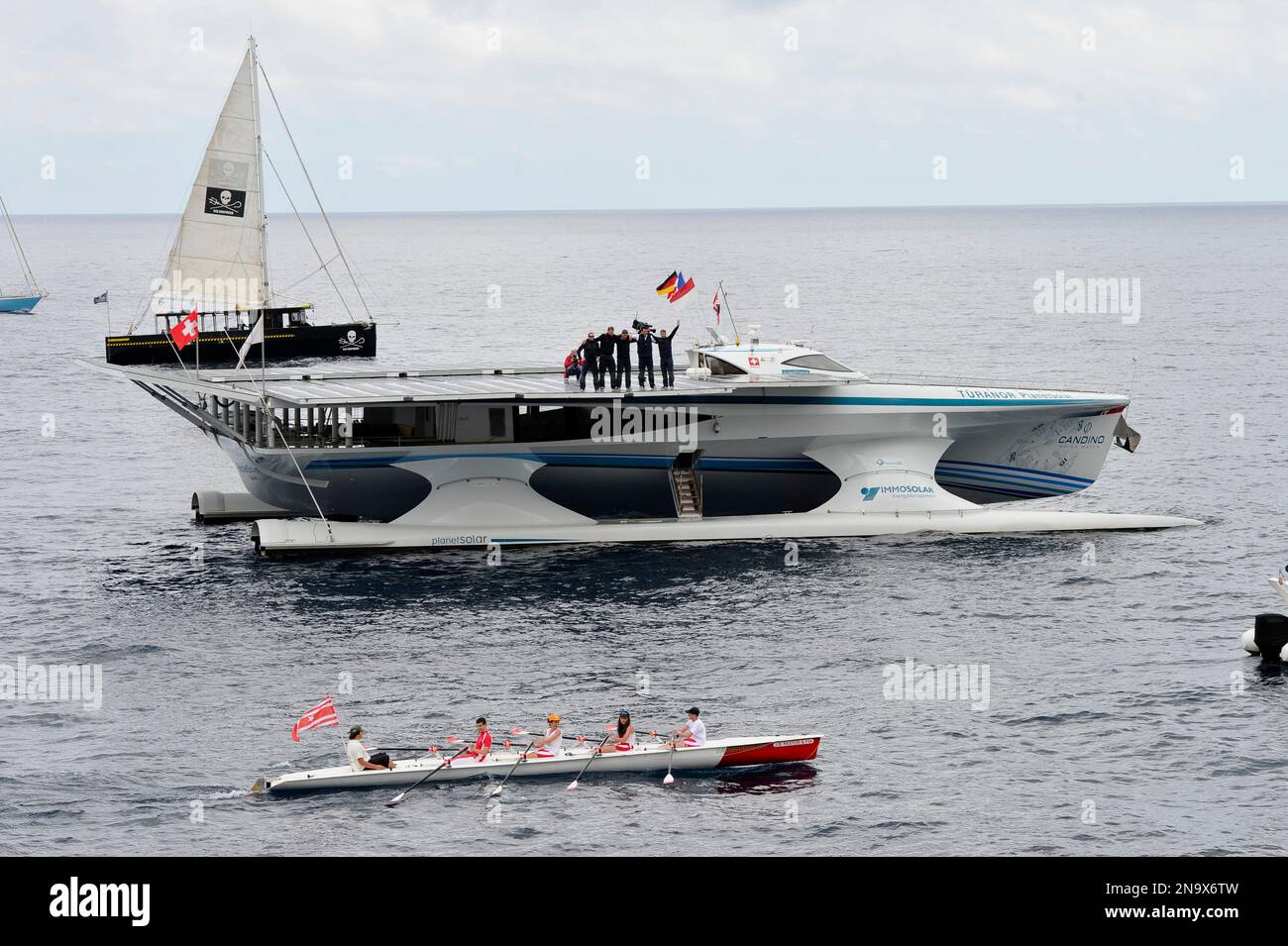 The sailors of the MS Turanor PlanetSolar, the world's largest solar boat ever built, stand on the deck after they have achieved the first around-the-world journey using solar energy in 585 days, off the Monaco's harbour, Friday, May 4, 2012. The five sailors are : Raphael Domjan of Switzerland, founder and expedition leader, Patrick Marchesseau of France, Erwann le Rouzic of France, Jens Langwasser of Germany and Christian Oechsenbeim of Switzerland. (AP Photo/Bruno Bebert) Stock Photo