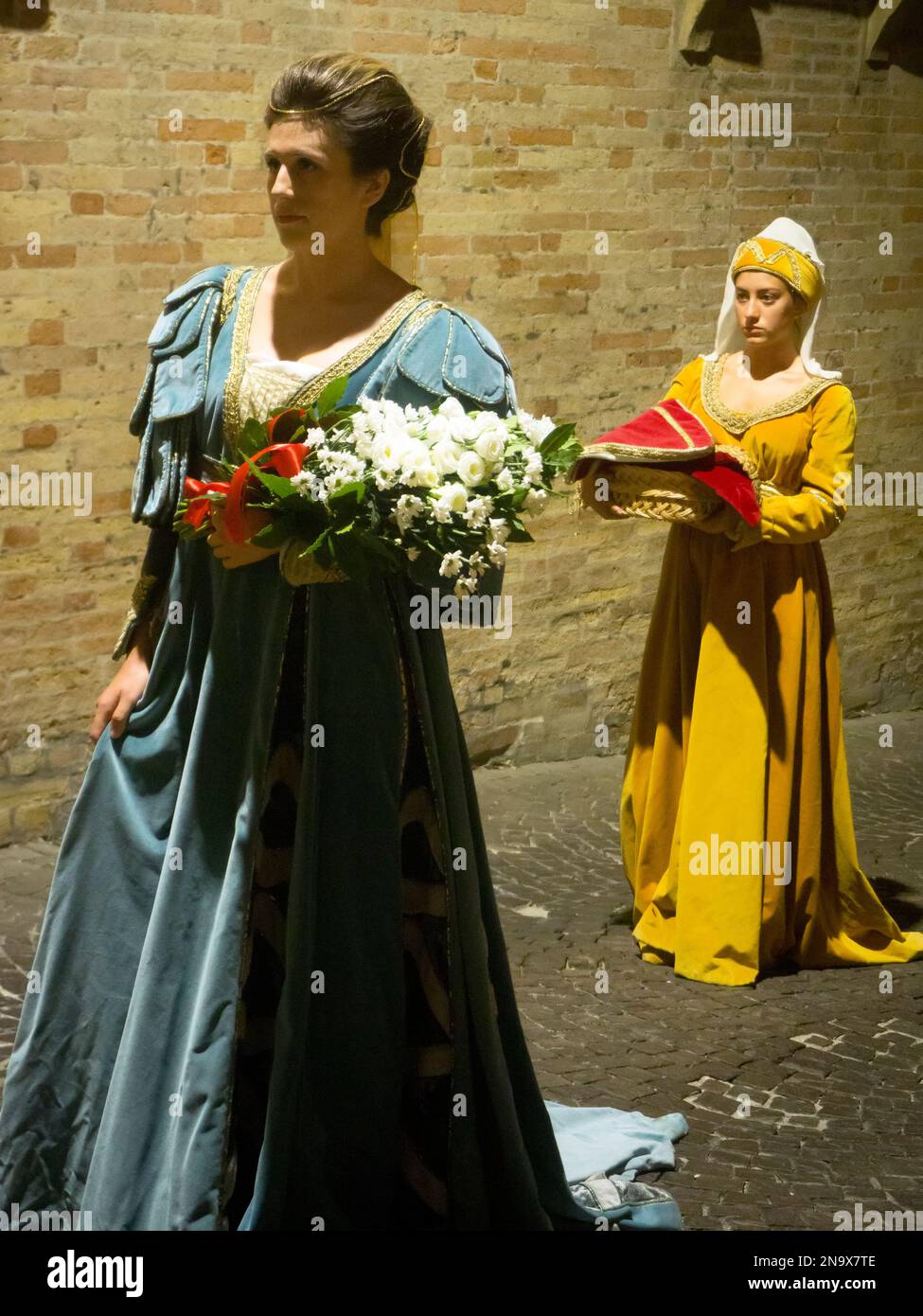 Lady and her maid dressed in late medieval, early renaissance costume parading the city streets at night, Fermo, Marche, Italy © Renzo Frontoni / Axio Stock Photo