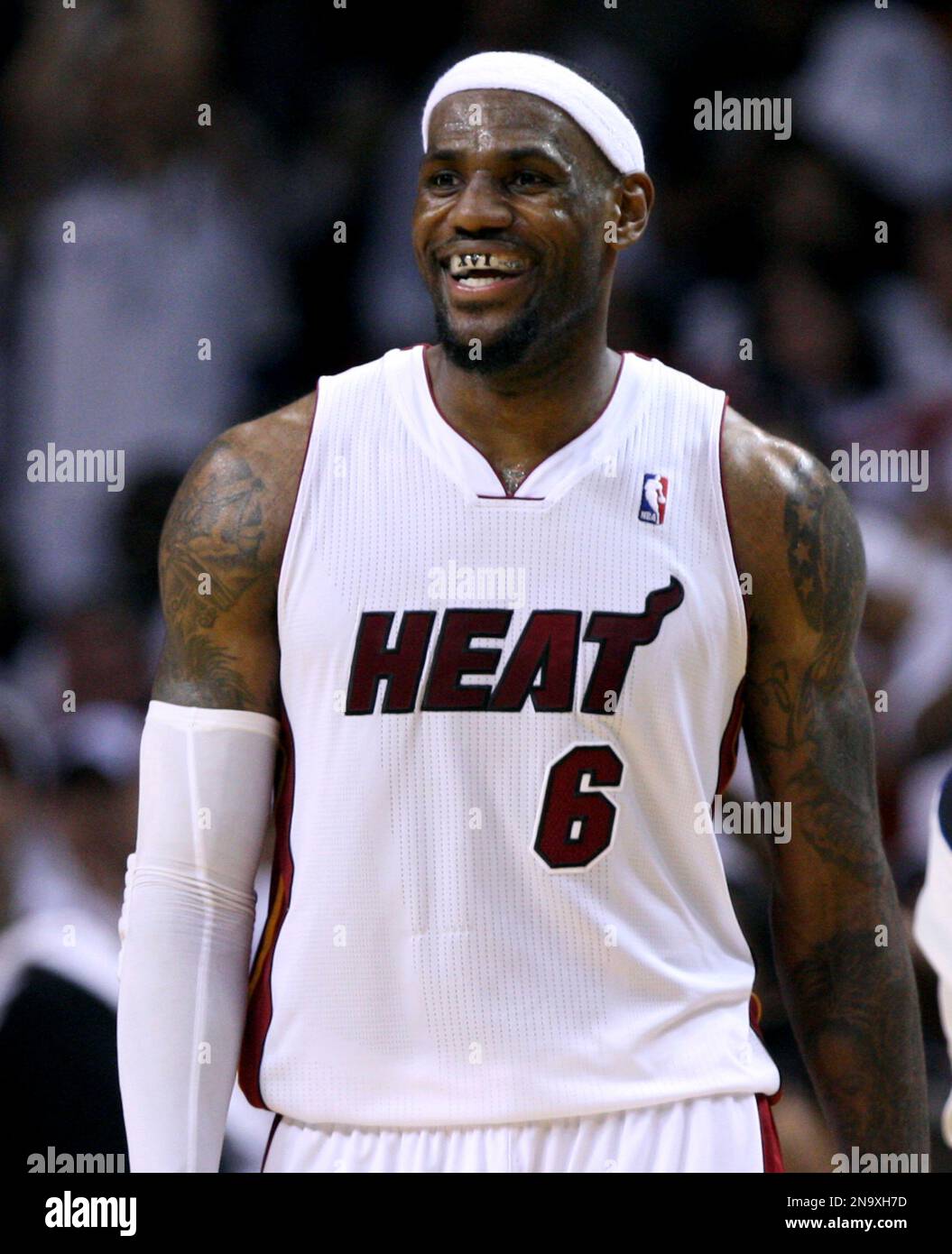 Miami Heat's LeBron James (6) smiles and shows his mouth guard reading XVI,  indicating the number of 16 games needed to win the NBA championship,  during an NBA basketball game against the