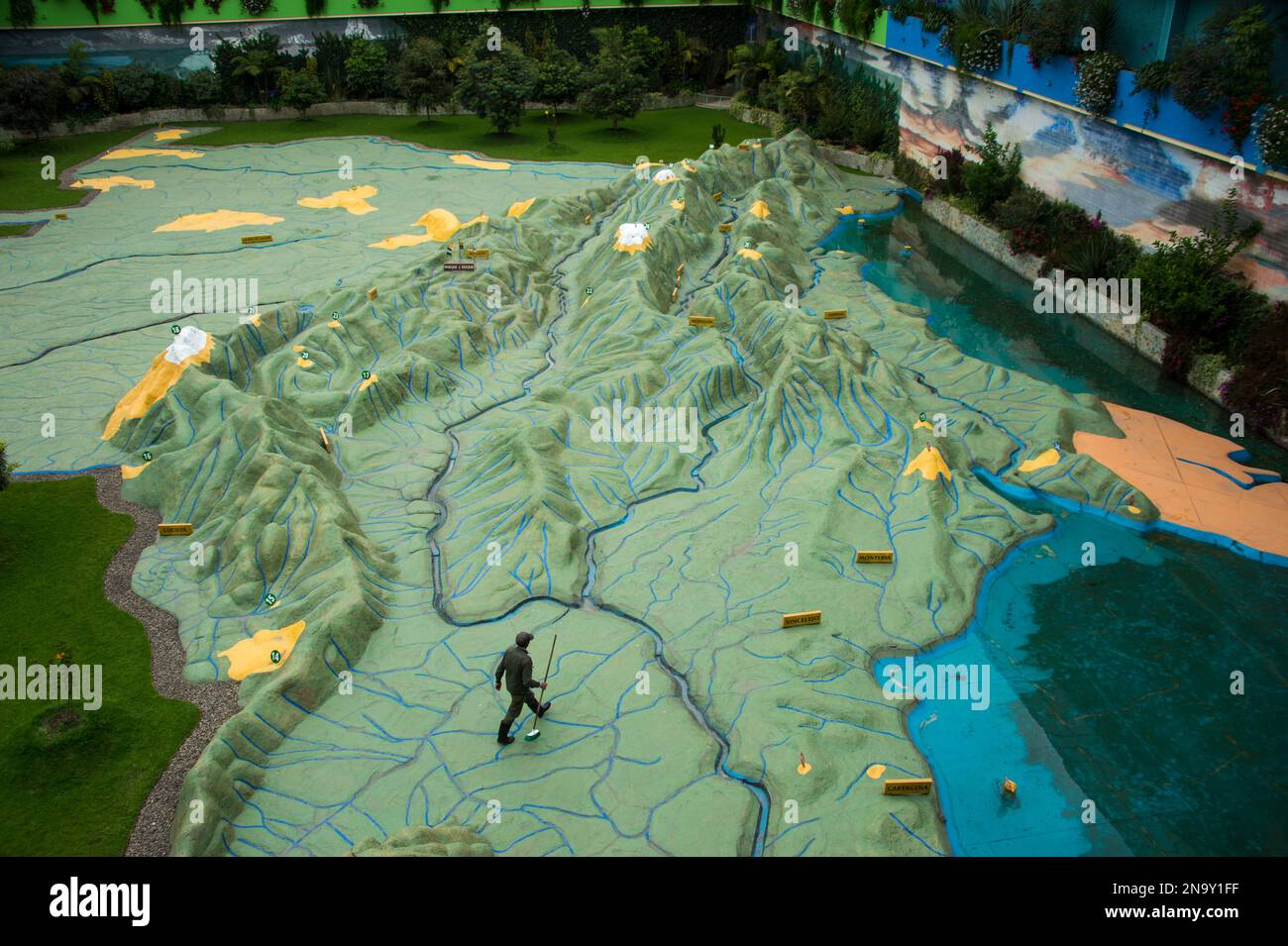 Staff member walks across a giant relief map of Colombia at Parque Jaime Duque; Bogota, Colombia Stock Photo