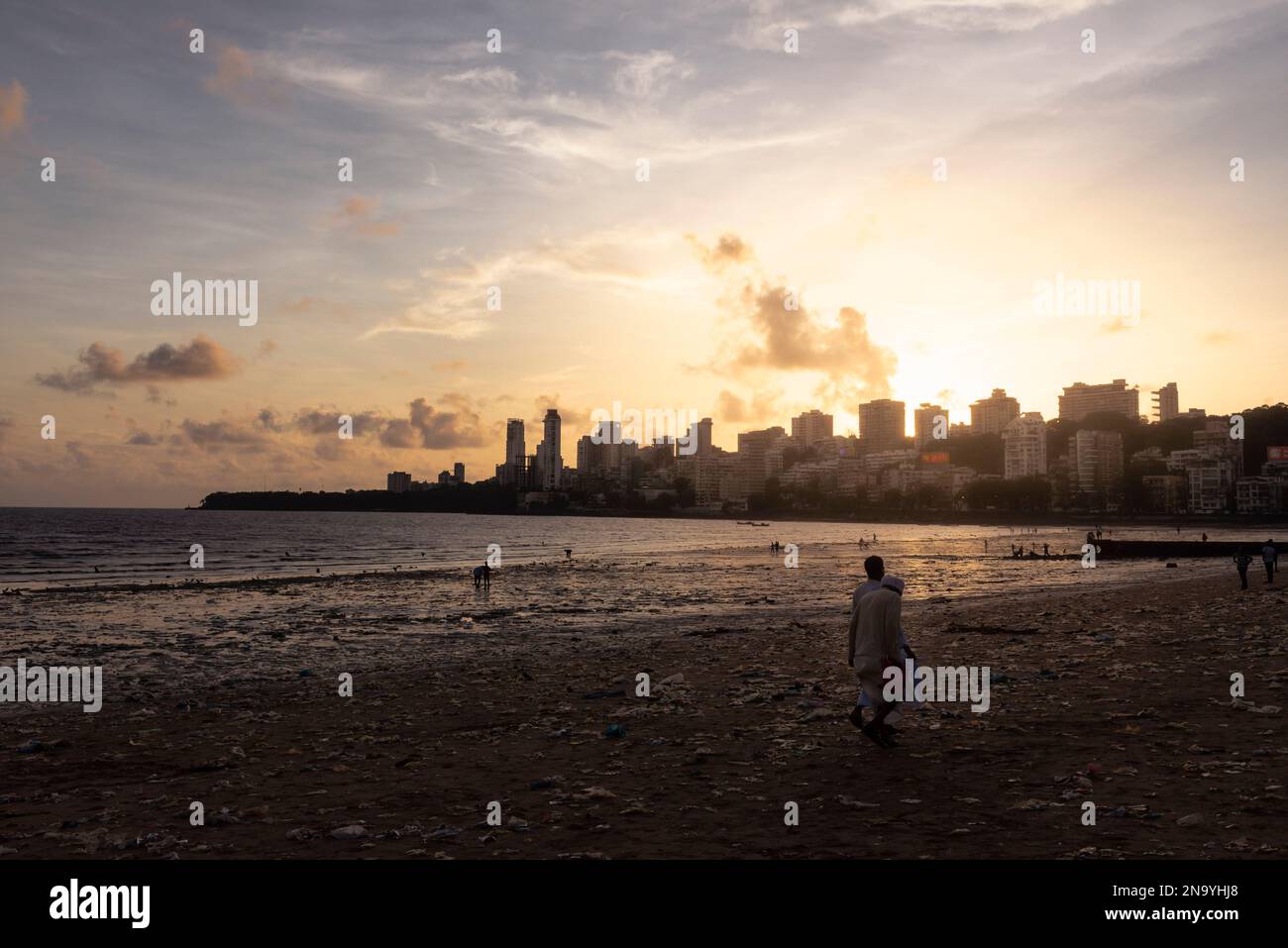 People on Chowpatty Beach at sunset with a view of the skyline in Mumbai; Mumbai, Maharashtra, India Stock Photo
