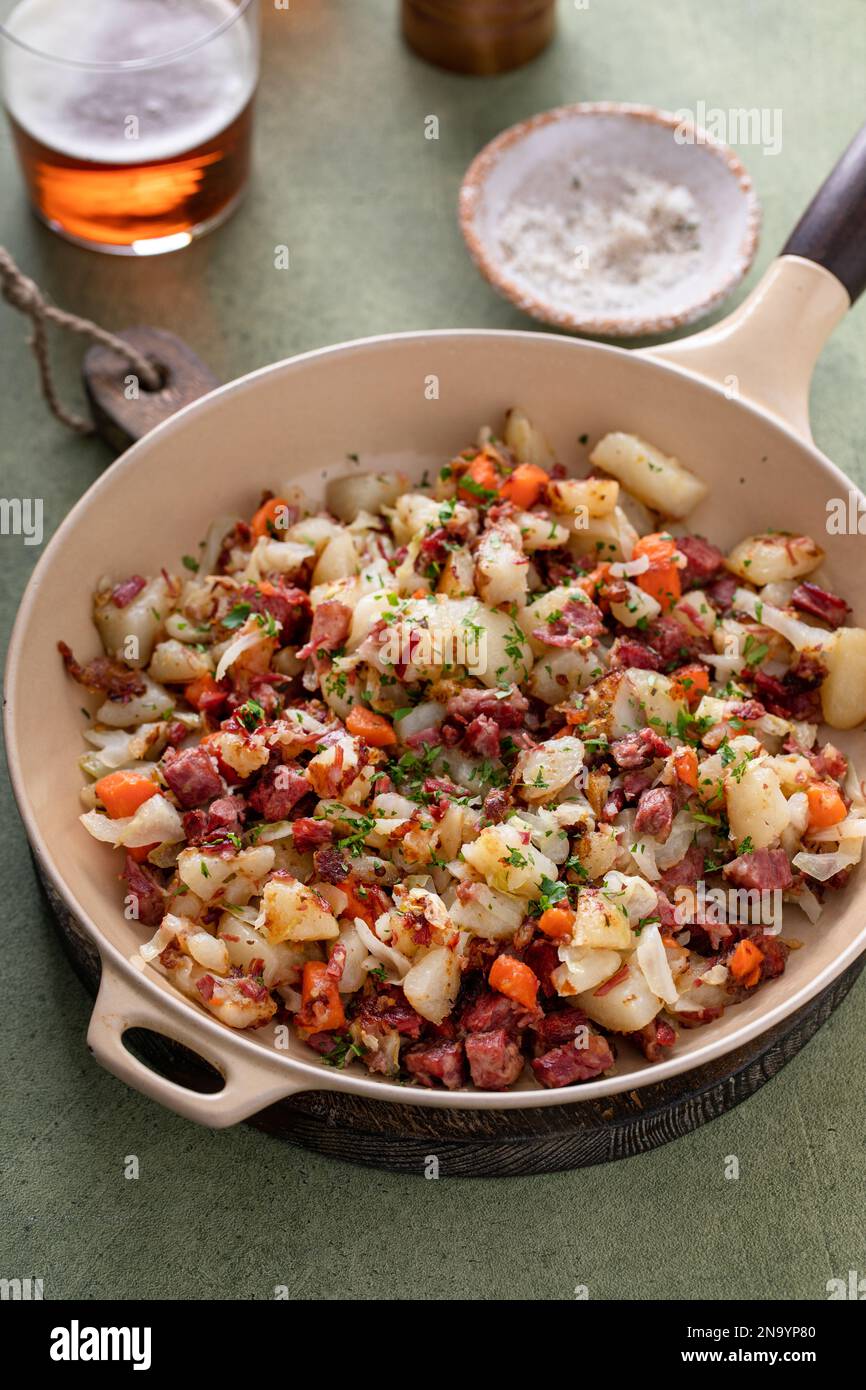 Corned beef hash with potatoes, cabbage and carrot in a cast iron pan