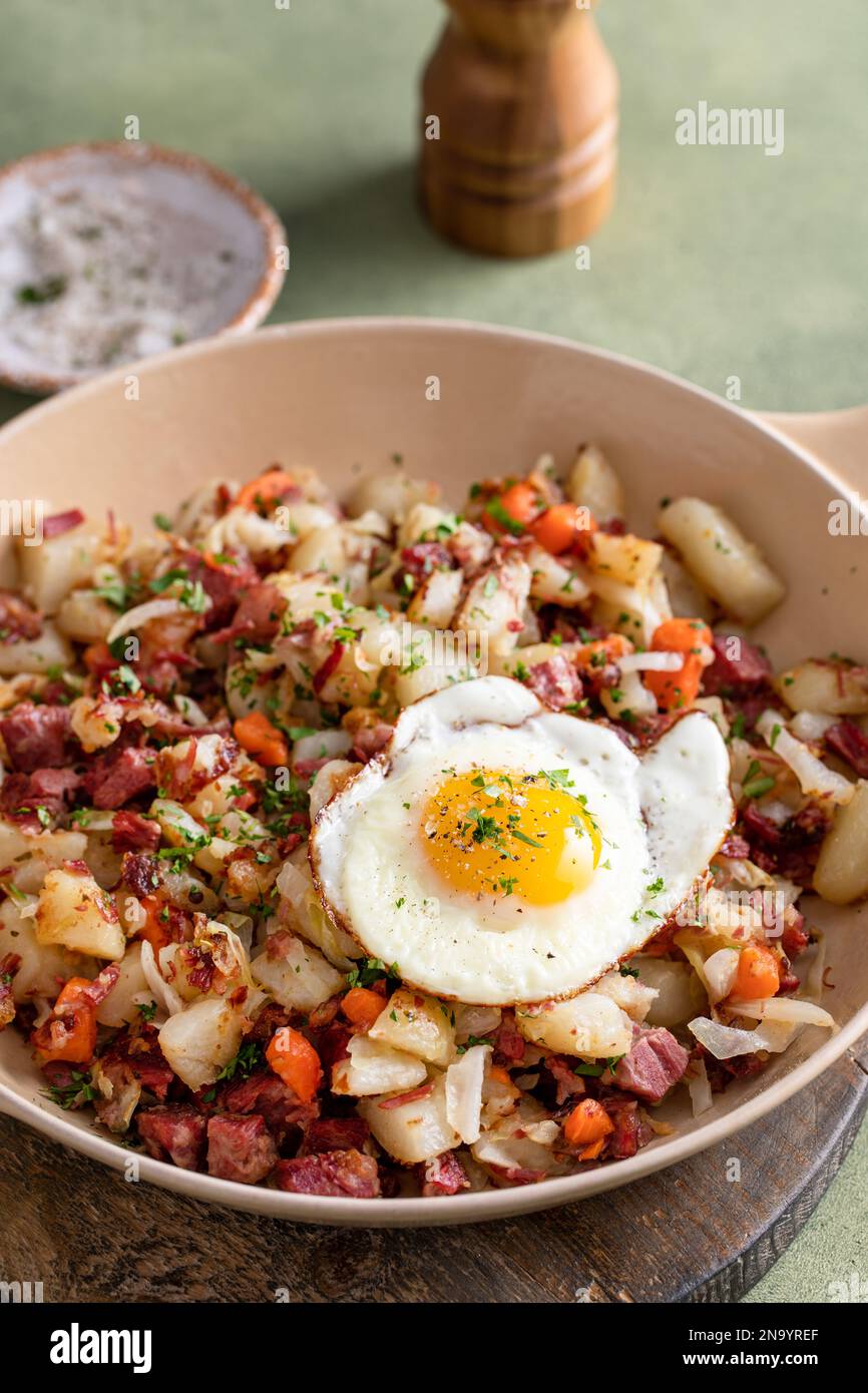 Corned beef hash with potatoes, cabbage and carrot in a cast iron pan