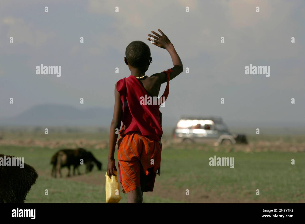 Masai child waves to tourists in Tanzania; Ndutu, Tanzania Stock Photo