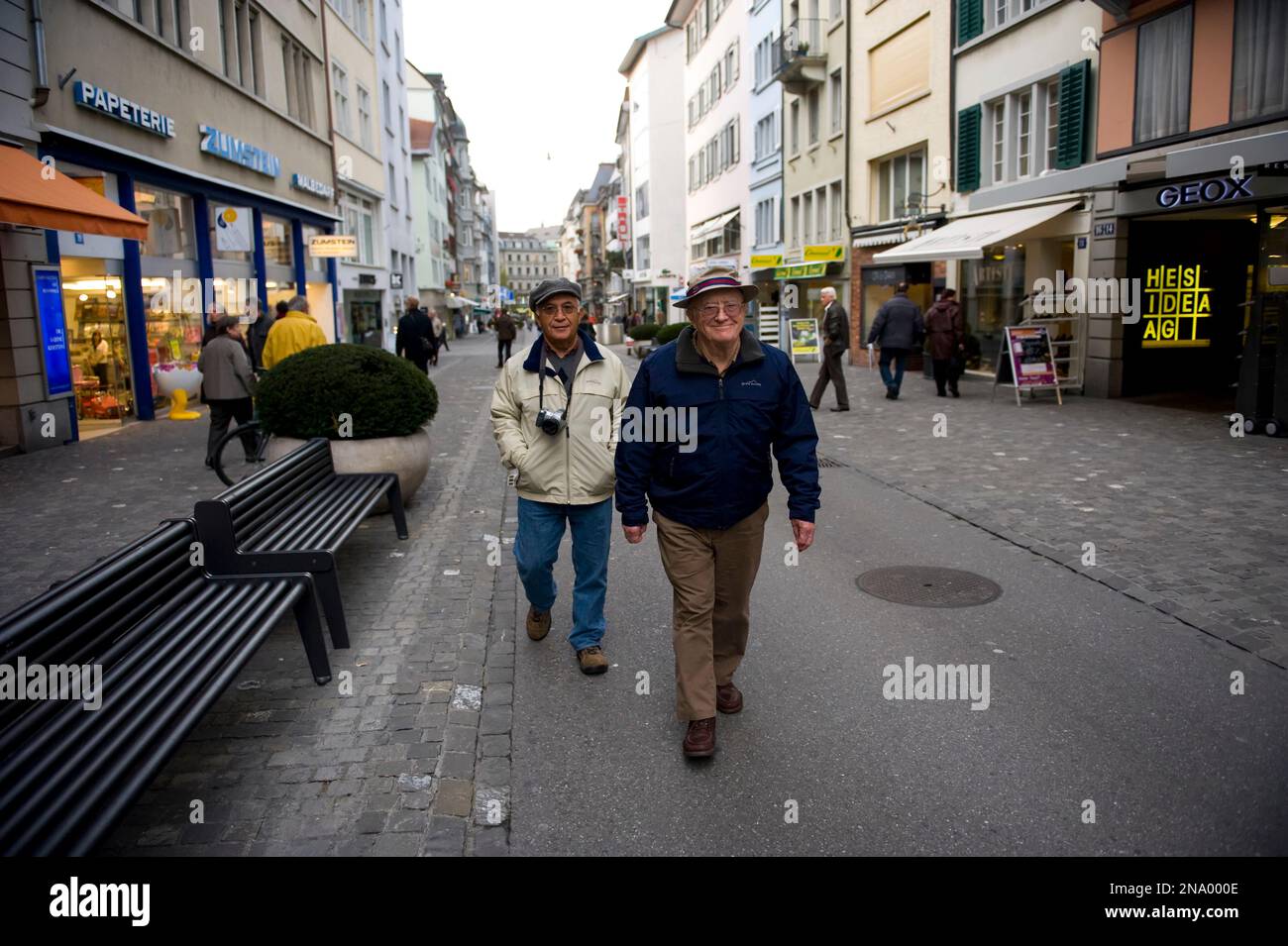 Two senior men stroll along a city street in Zurich, Switzerland; Zurich, Switzerland Stock Photo