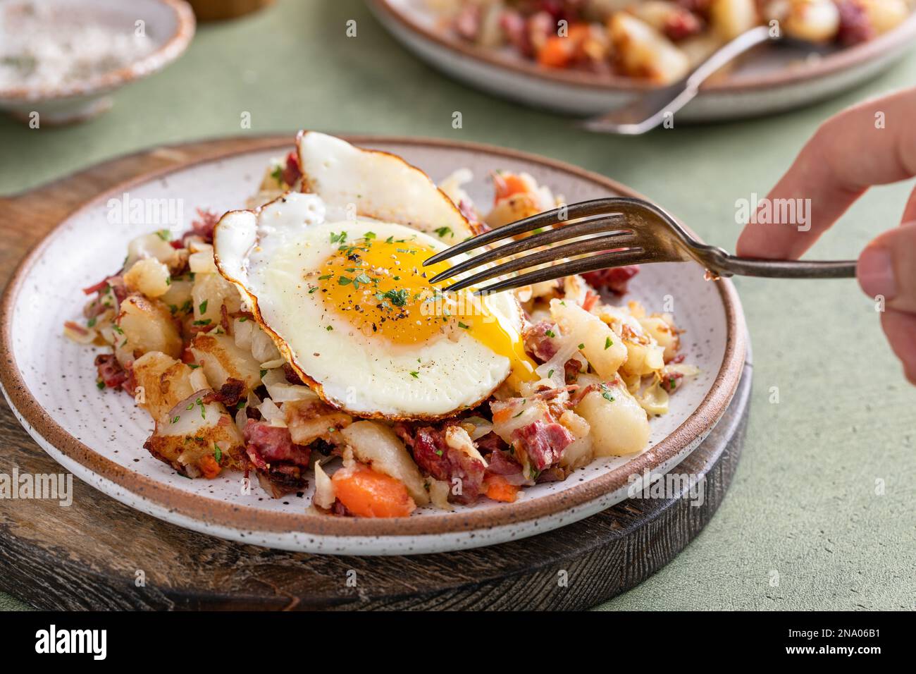 Corned beef hash with potatoes, cabbage and carrot on a plate topped