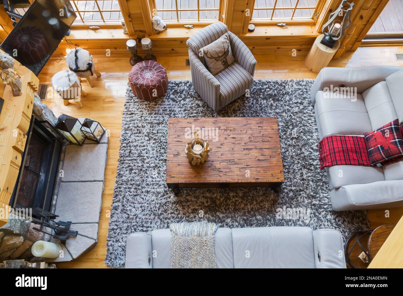 Top view of taupe leather sofas, grey and white striped cloth armchair