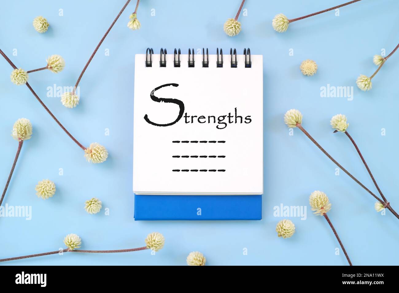 List of personal strengths written on blue notepad. Personality development beautiful flat lay composition. Stock Photo