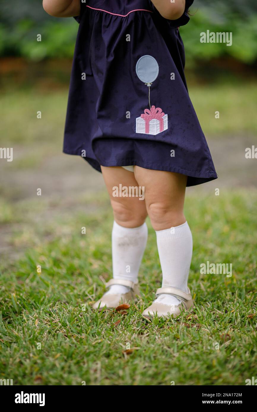 Chunky and cute little toddler two year old girl legs with tall white socks and dress shoes
