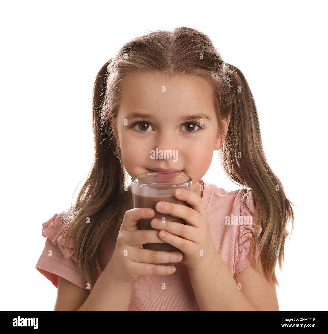 Cute little girl drinking chocolate milk on white background Stock
