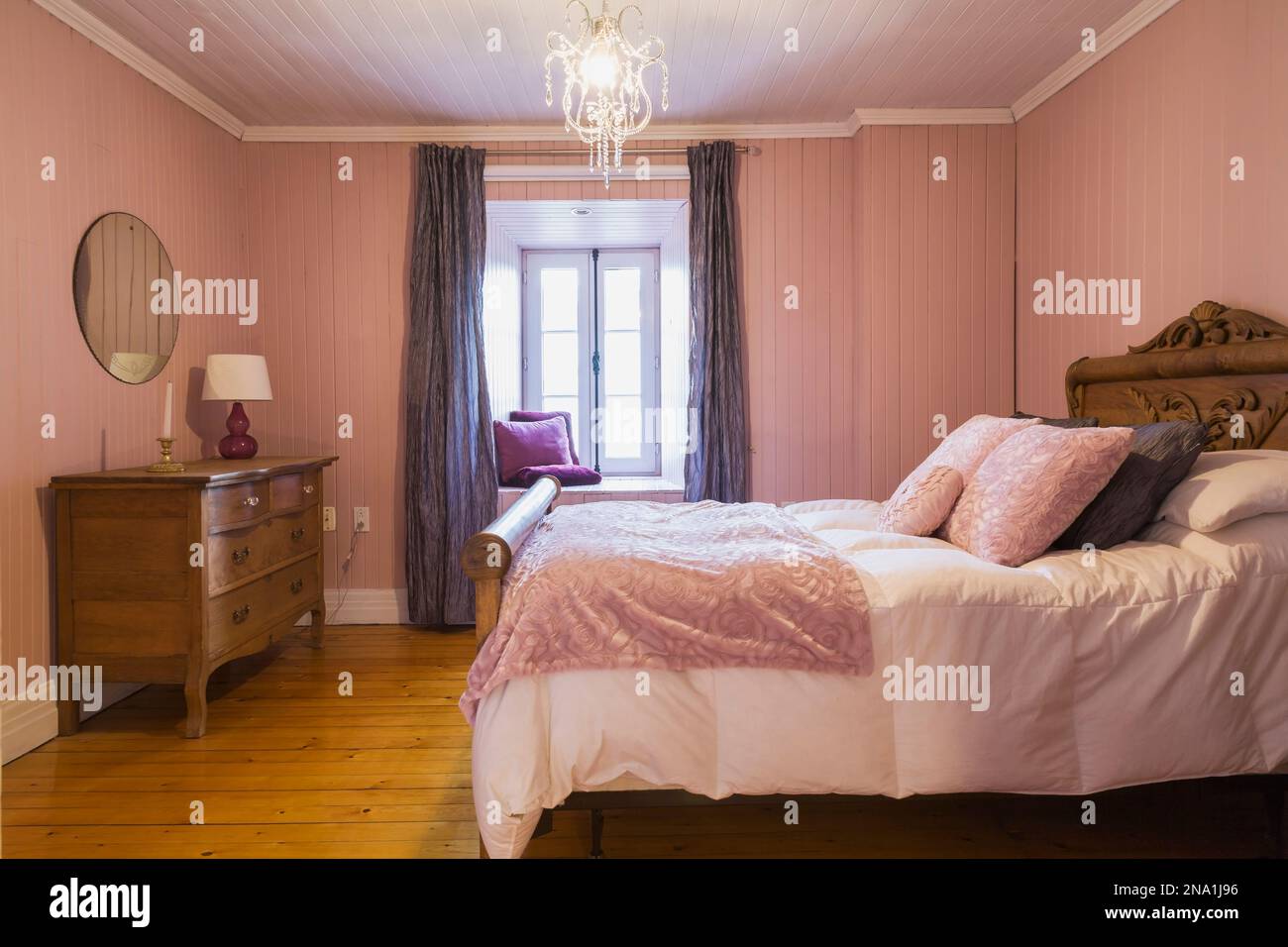 Threequarter bed with white bedspread and antique wooden headboard and