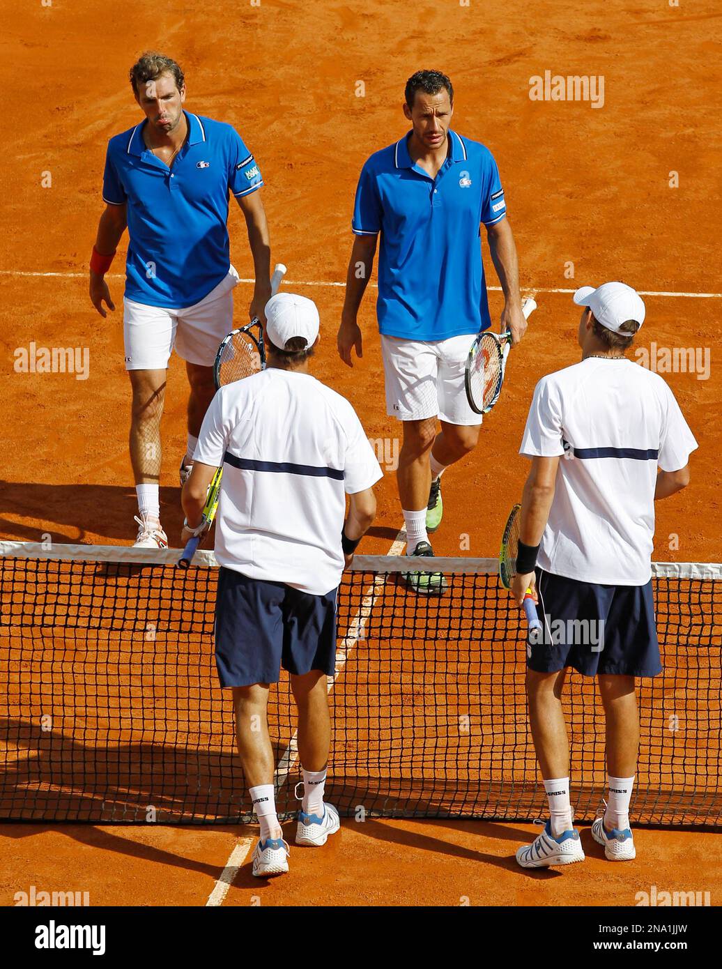 U.S. players Mike Bryan and Bob Bryan, foreground prepare to shake hands with French players