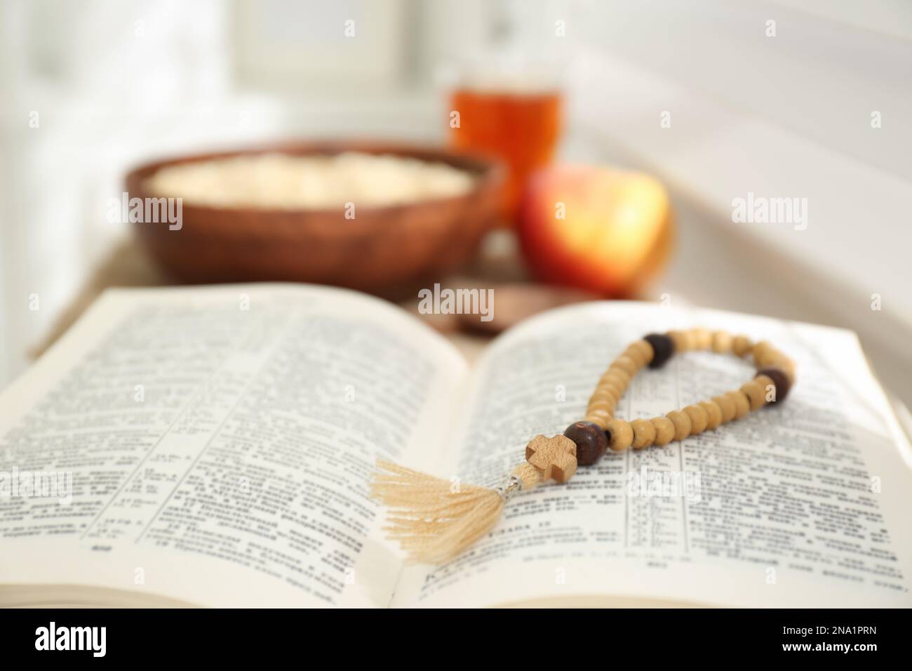 Holy Bible with prayer beads on window sill indoors, closeup. Great ...